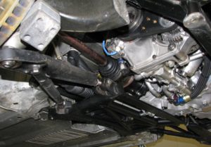 Il telaietto anteriore tubolare a cui sono ancorati, tramite uniball così come sui montanti, i triangoli inferiori. Si notano i doppi punti di fissaggio del braccio oscillante e del tirante tramite cui si può variare l’incidenza. Si scorgono anche le pompe di recupero dell’olio, per l’impianto a lubrificazione a carter secco, nella parte inferiore del blocco motore. 